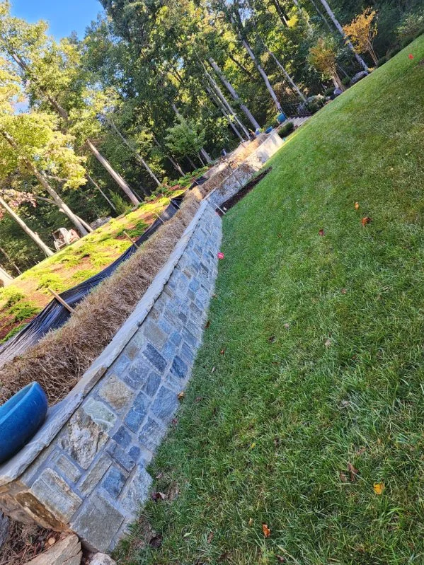A long block retaining wall holding the grade along a lawn
