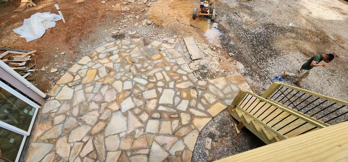 Irregular flagstone patio at the foot of a new deck stair