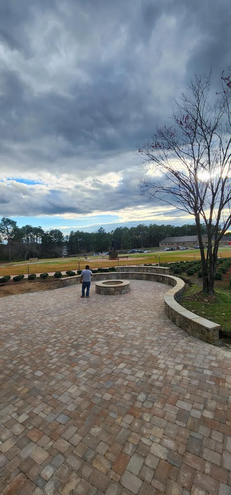 Curved stone seat wall wrapping a large paver patio